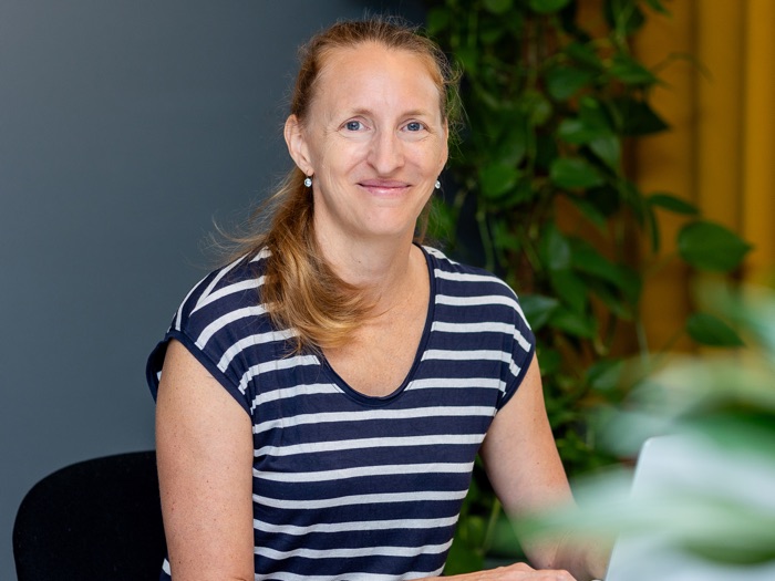 Katja Werzner am Laptop, sie lächelt in die Kamera